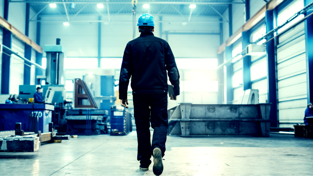 Servicing person walking through a factory